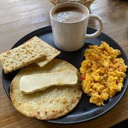 Arepa, huevos revueltos, galletas y chocolate.