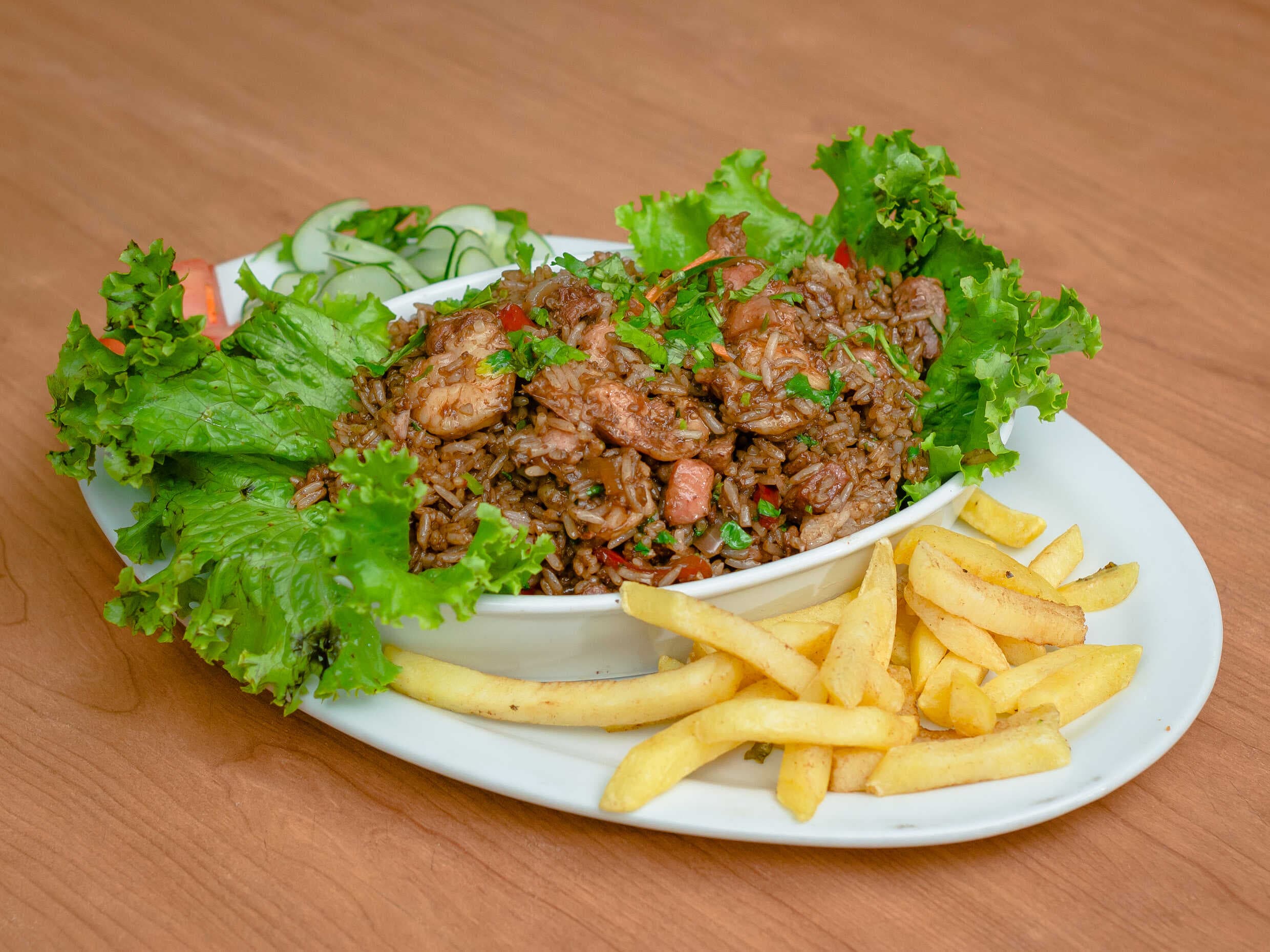 Paella carne y mariscos y papas fritas hiel