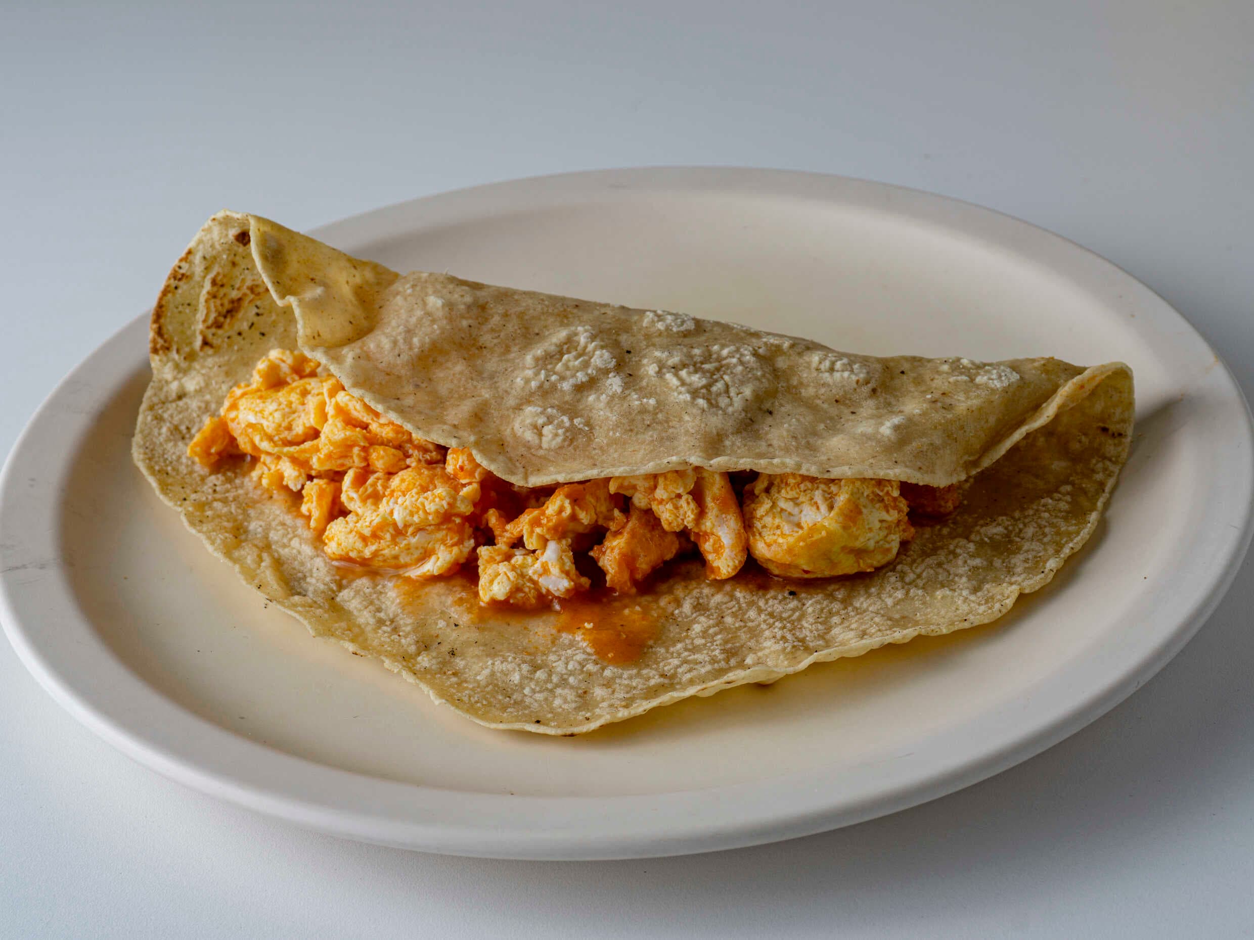 Taco de huevo en salsa roja.