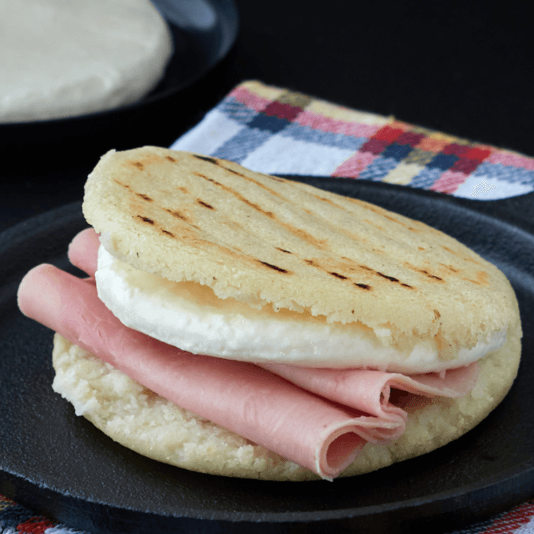 Arepa con jamón y queso de mano