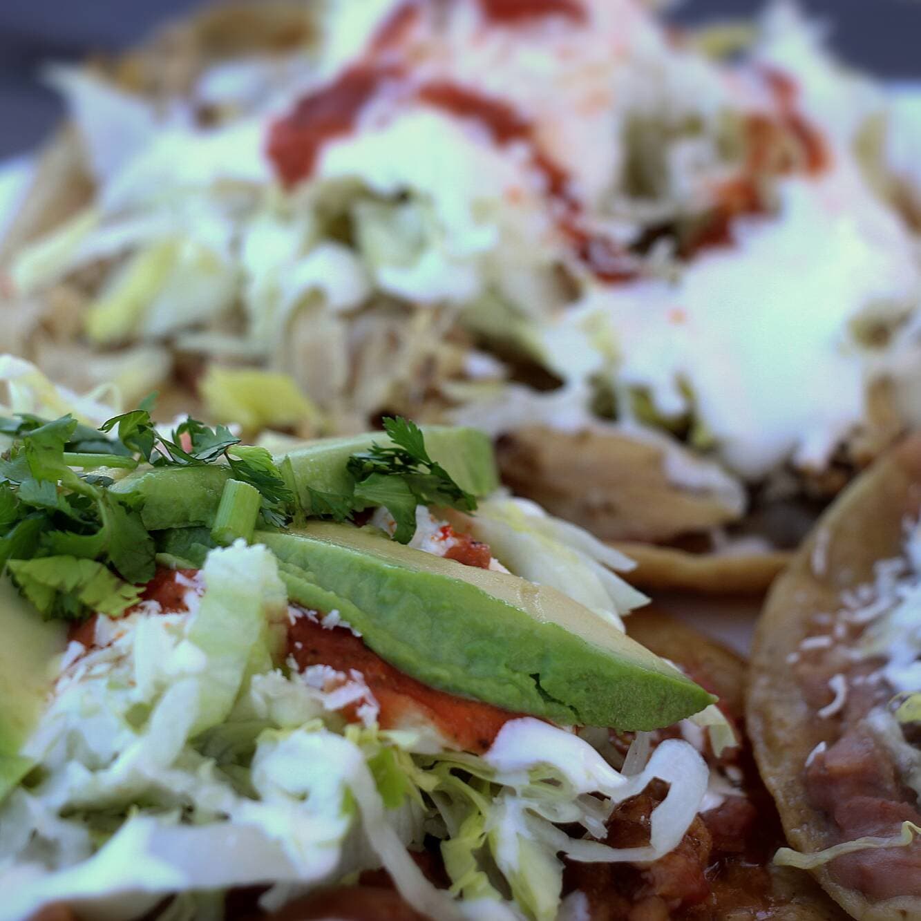 Tostada Deshebrada con papa, Lechuga, Crema, Queso