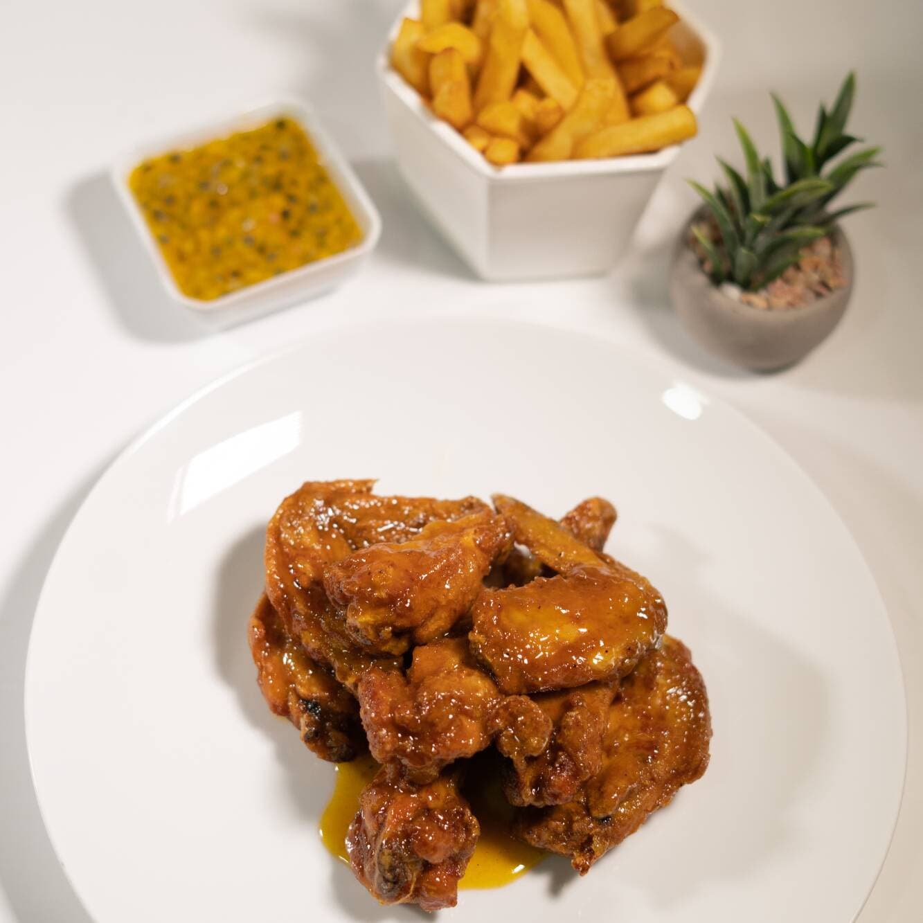 Alitas Maracuyá Picante y Papas a la Francesa.