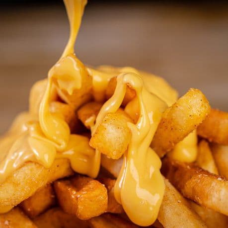 Papas con salsa de queso cheddar