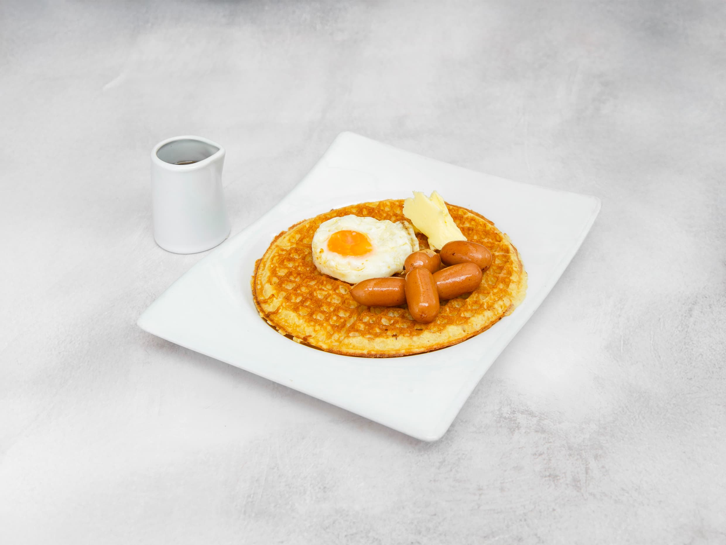 Waffle syrup, huevo frito y salchichas.