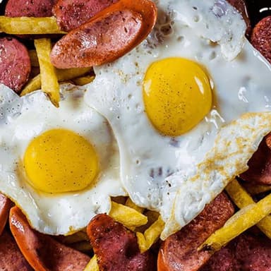 Salchipapa Colombiana con Tocineta y huevo