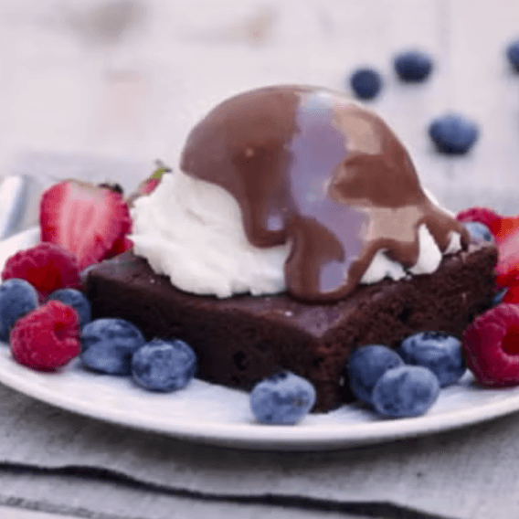 Brownie con helado y fruta