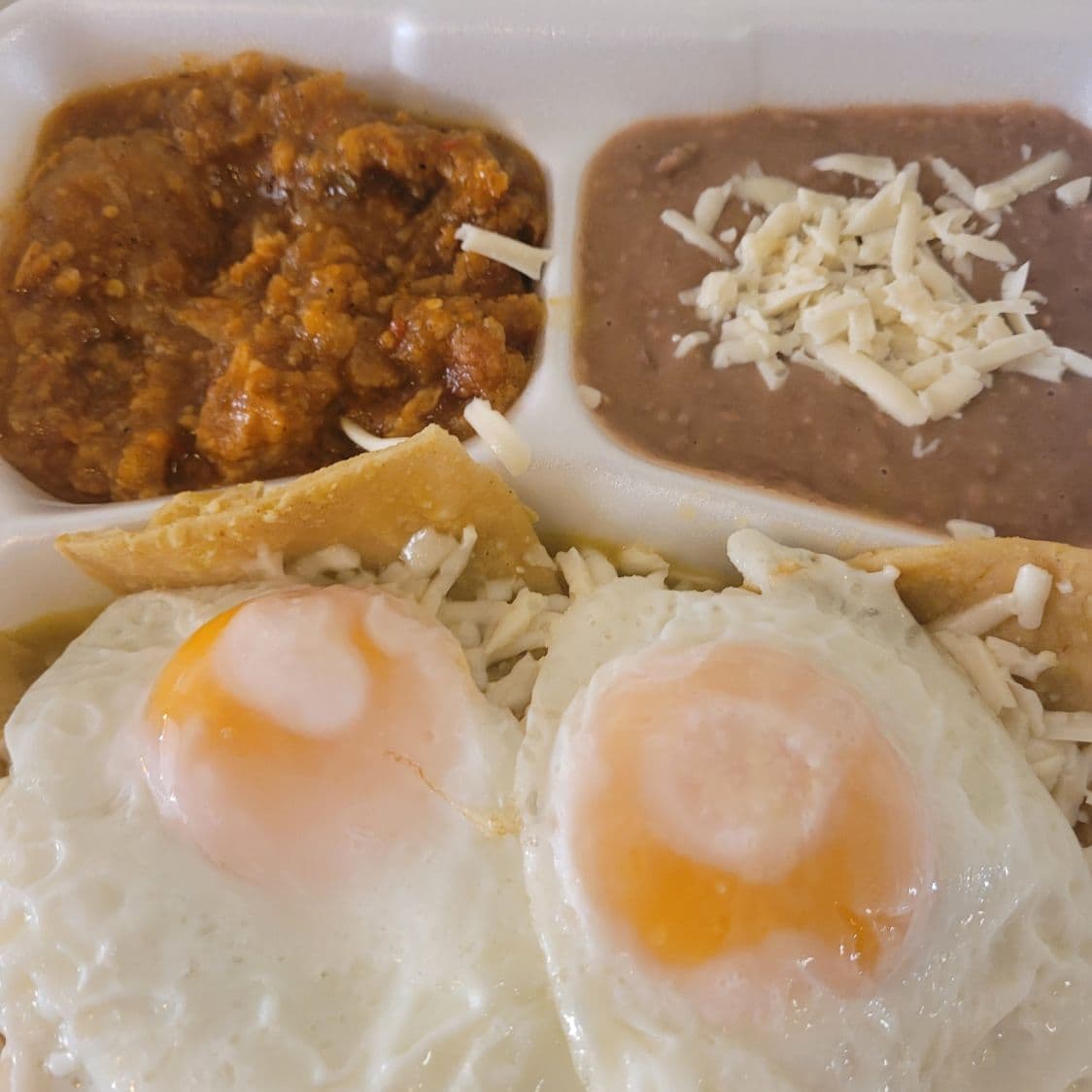 Chilaquiles verdes montados con huevos estrellados