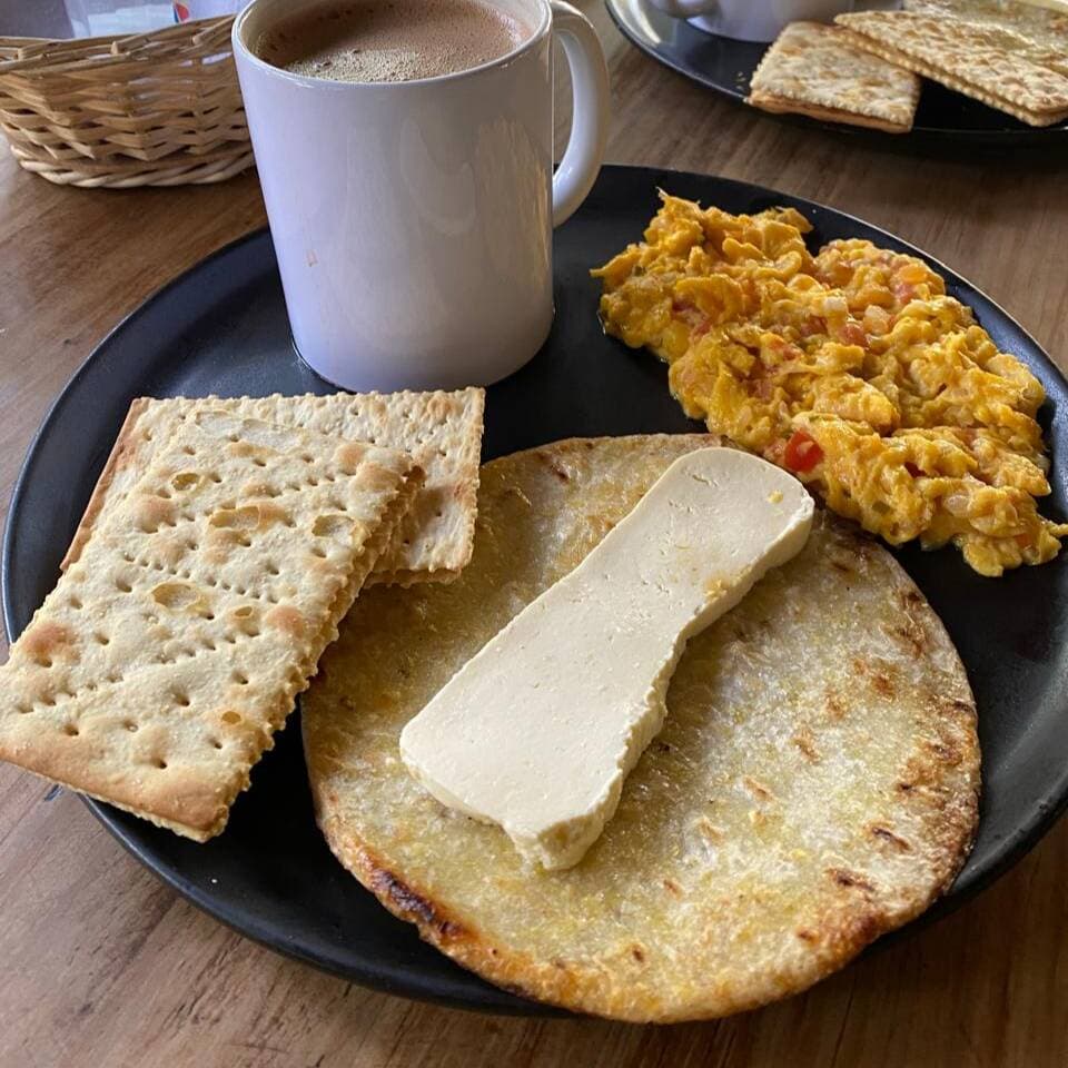 Arepa, quesito, huevos revueltos al gusto (tomate,