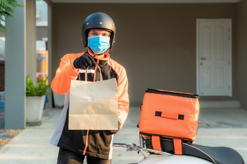Repartidor en motocicleta entregando una bolsa