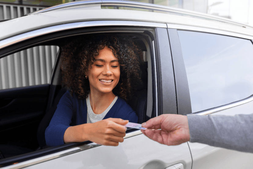 Mujer conduciendo evitando multa por traer licencia