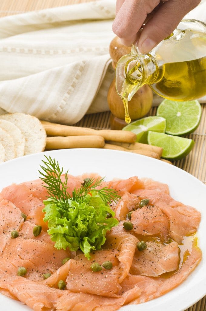 Carpaccio de salmón con aceite de oliva, condimentos y limón