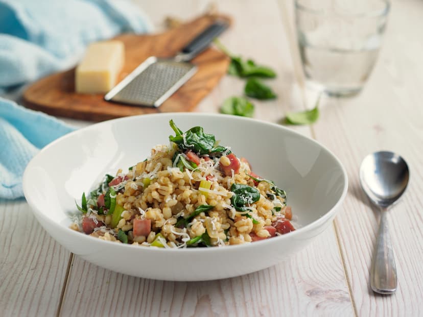 Risotto de cebada y tomate en plato hondo blanco
