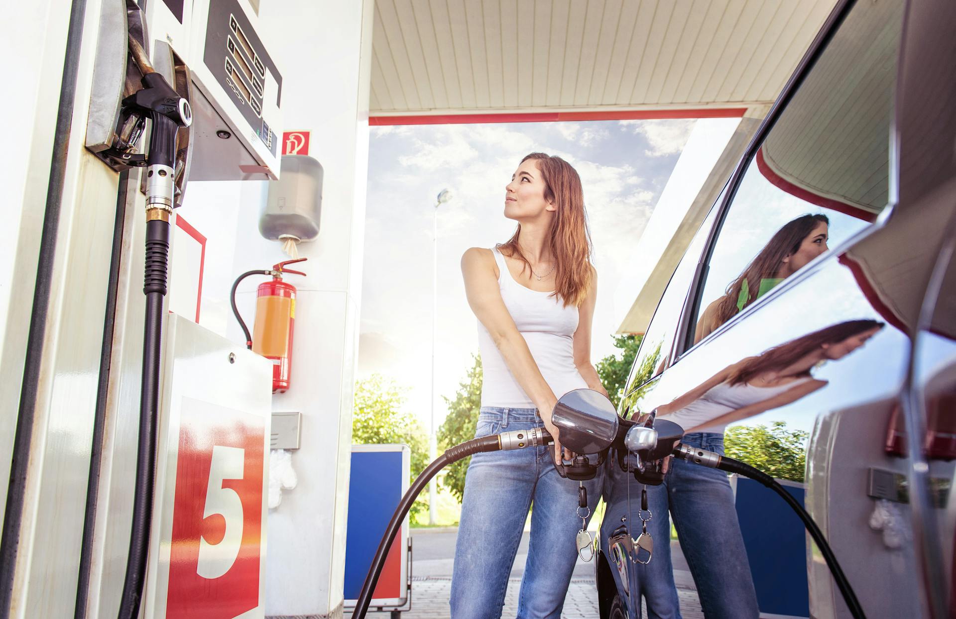 Mujer poniendo gasolina a su auto