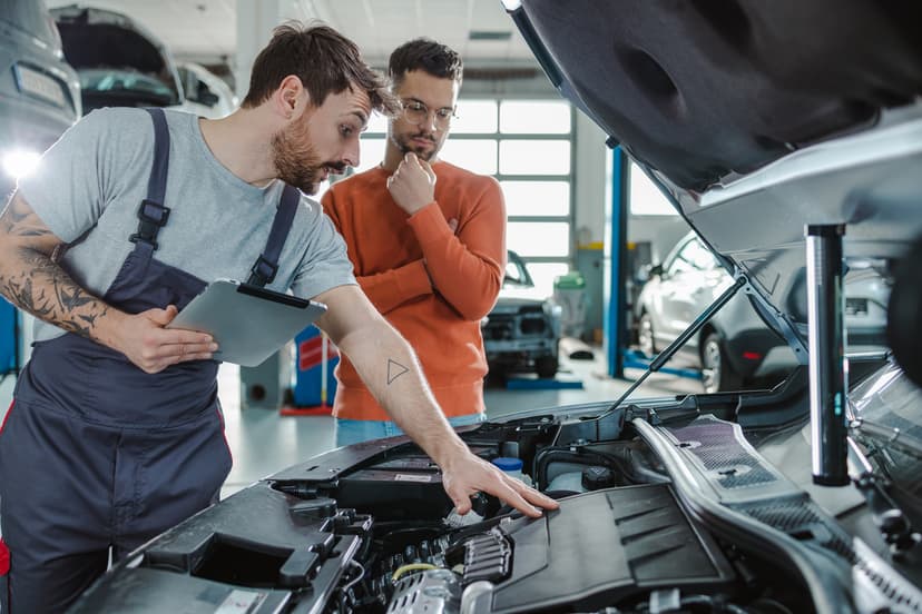 Mecanico y cliente frente a coche