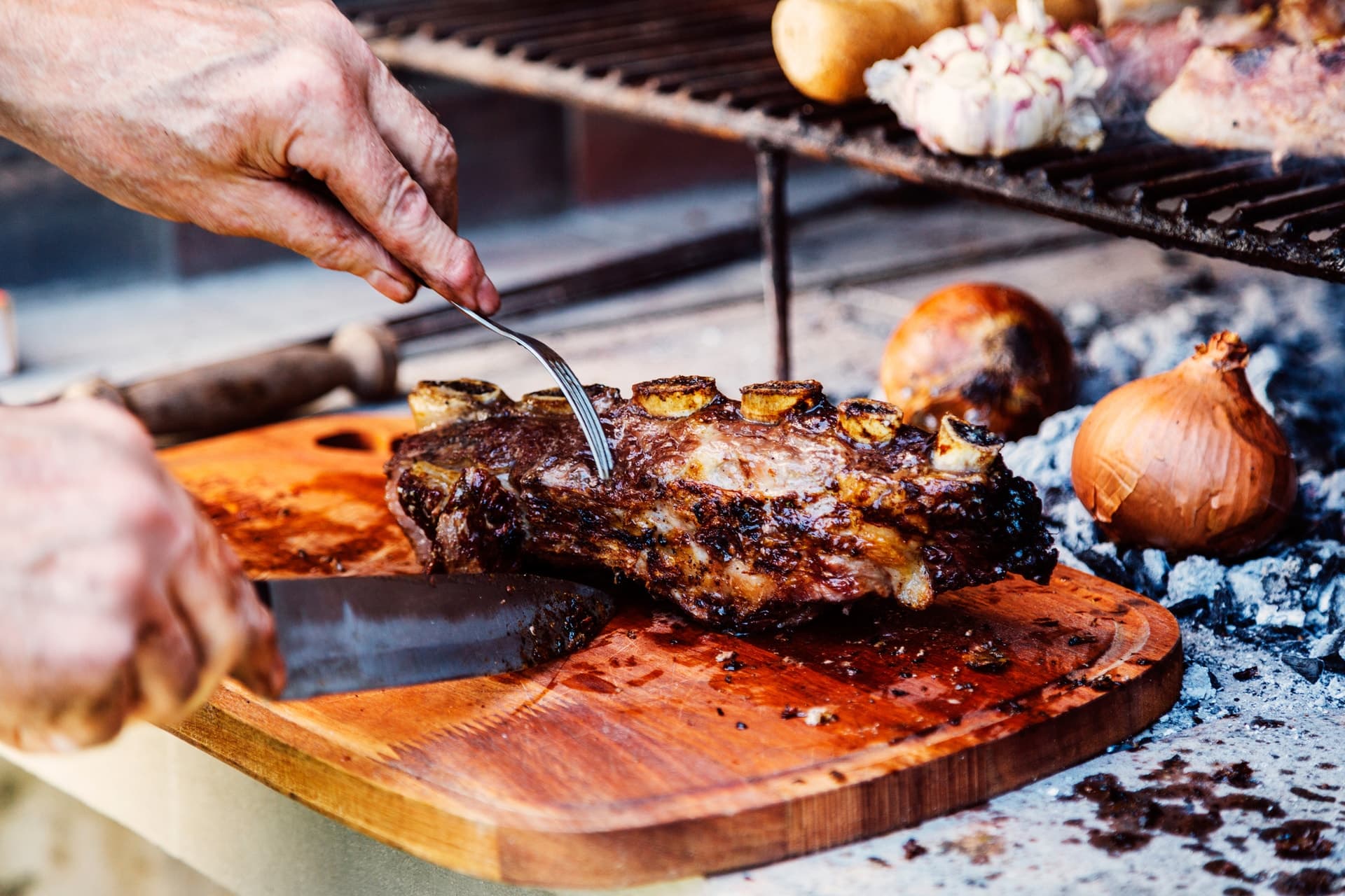 Hombre cortando un costillar en un restaurante argentino