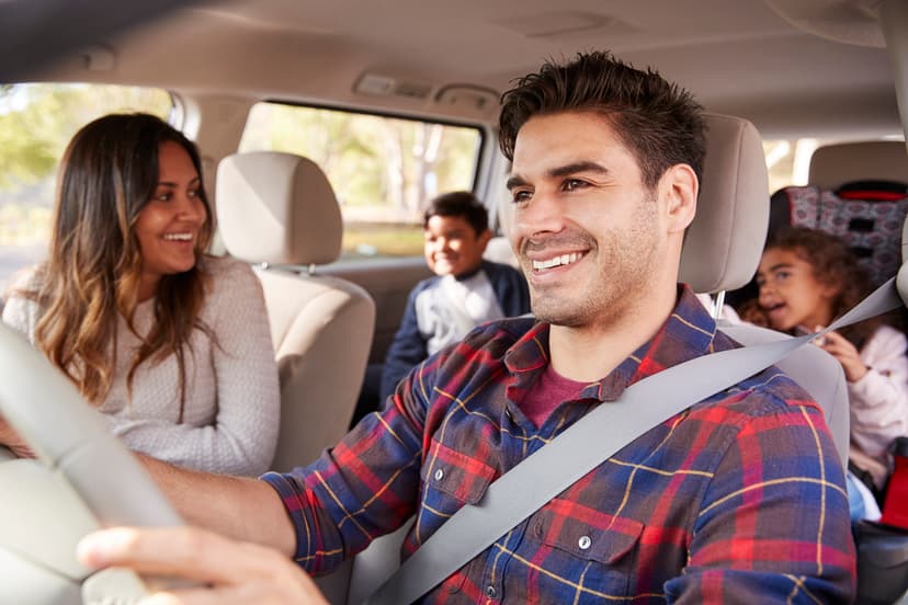 Familia viajando con niños pequeños que van en su silla de seguridad para evitar algún accidente