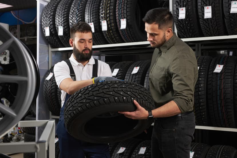 Vendedor y cliente eligiendo llantas