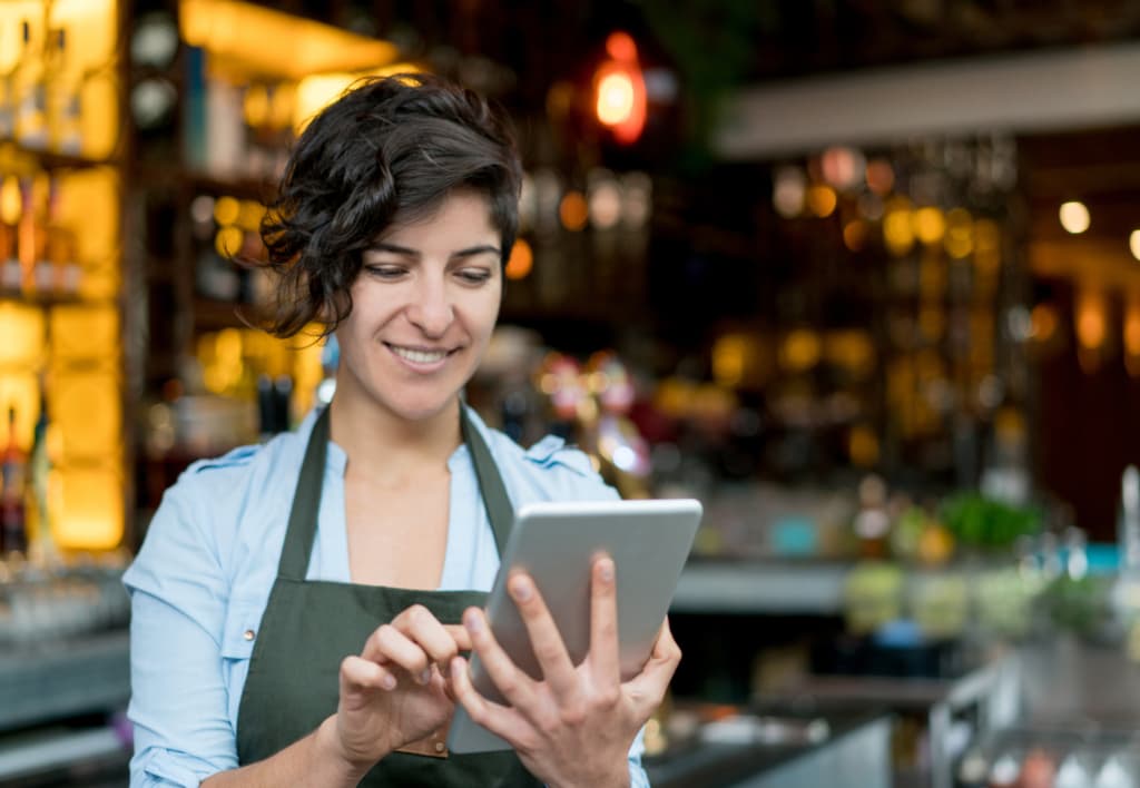 Girl smilling while she uses a mobile device.